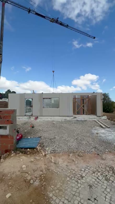 Grua a colocar painel na estrutura da casa no Algoz